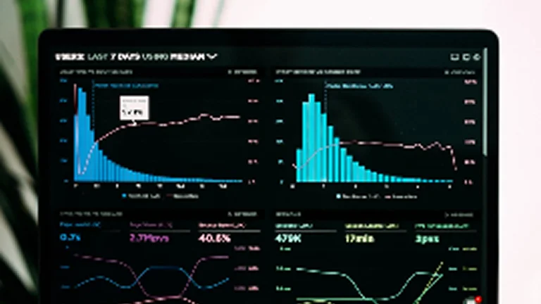 A computer screen displays multiple data charts and graphs with lines and bar graphs in blue, pink, and green on a dark background. A plant is blurred in the background.